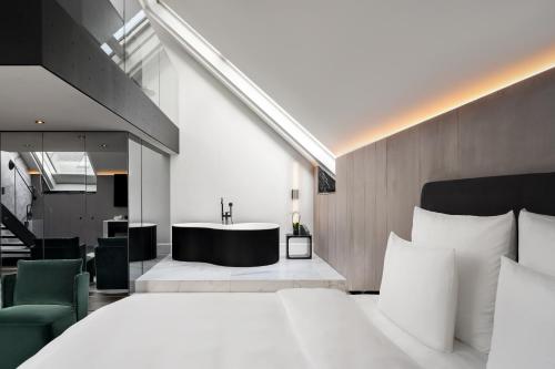 a bedroom with a large bed and a bath tub at The Amauris Vienna - Relais & Châteaux in Vienna