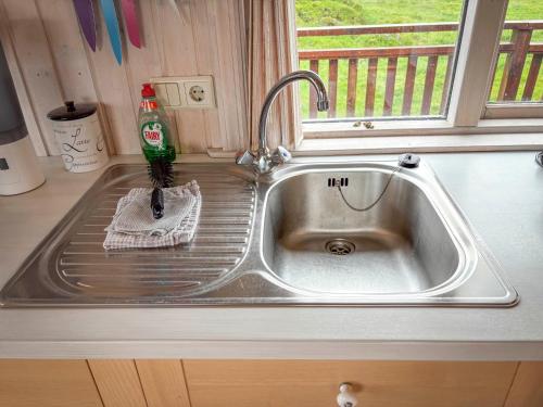 a sink in a kitchen with a bottle of soda at Áshamrar in Hella