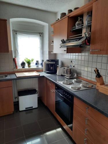 a kitchen with a sink and a stove top oven at Gemütliches Häuschen in Schmalenberg
