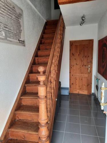 a wooden staircase with a wooden door in a room at Gemütliches Häuschen in Schmalenberg