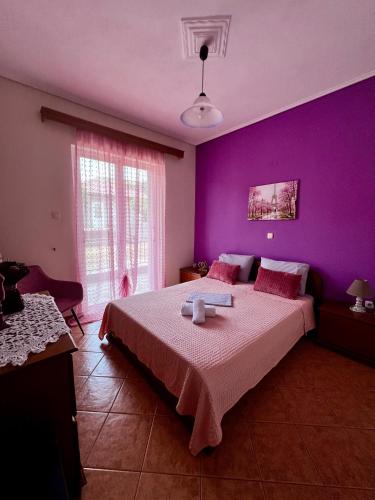 a bedroom with purple walls and a large bed at Kolovos House in Karyes