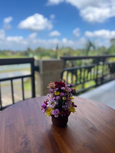 a small vase of flowers sitting on a table at Heaven Villa Ubud in Ubud