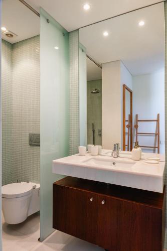 a bathroom with a sink and a toilet and a mirror at Pool Beach & Golf Troia Reserve V3 in Troia