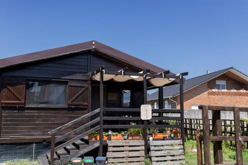 a house with a porch with an umbrella at Gothes Chalet Javier in Ponte de Vagos