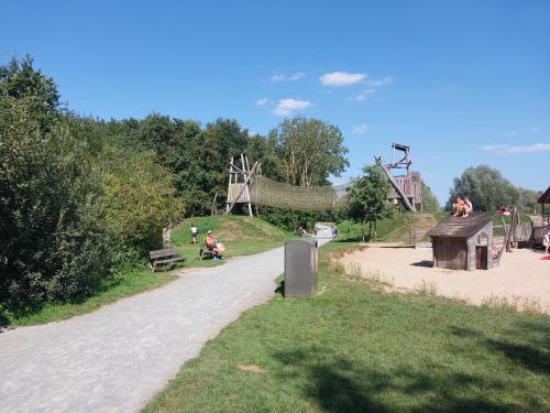 a dirt road next to a park with a playground at Lake Harelbeke in Harelbeke
