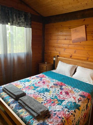 a bedroom with a bed with two towels on it at Gothes Chalet Javier in Ponte de Vagos