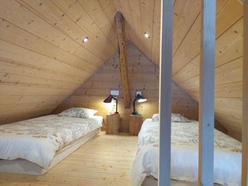 - 2 lits dans une chambre mansardée avec des plafonds en bois dans l'établissement Logement entre lac et montagne, à Annecy