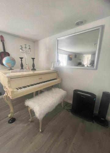a living room with a piano and a mirror at Tiny but cozy manufactured house in Tampa