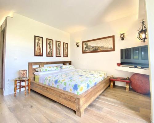 une chambre avec un lit et une télévision à écran plat dans l'établissement Kantaldi, à Guéthary