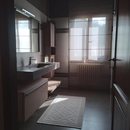 a bathroom with a sink and a mirror and a window at Villa el Pavo Real Arezzo in Arezzo