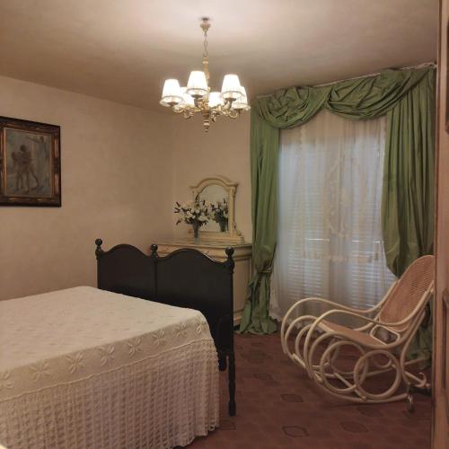 a bedroom with a bed and a chair and a window at Villa el Pavo Real Arezzo in Arezzo