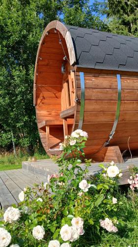a small wooden boat with a circular window in a garden at B&B Klarälvsbanan in Deje