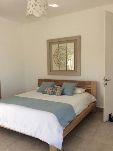 a bedroom with a large bed with blue pillows at Superbe penthouse sur la plage in Riambel