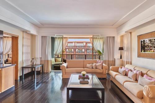a living room with a couch and a table at Hôtel & Ryads Barrière Le Naoura in Marrakech
