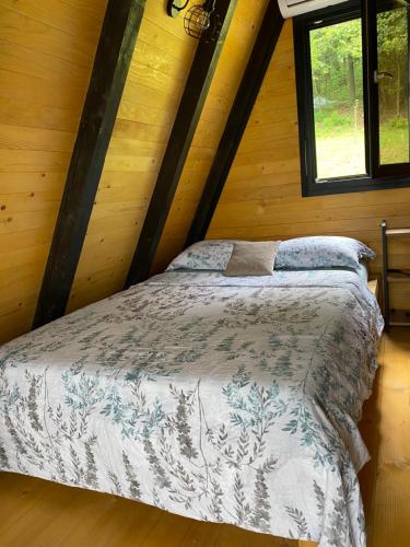 a bedroom with a bed in a wooden cabin at Vila Edi Tuzla in Tuzla