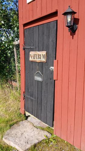 a red and black door with a sign on it at B&B Klarälvsbanan in Deje