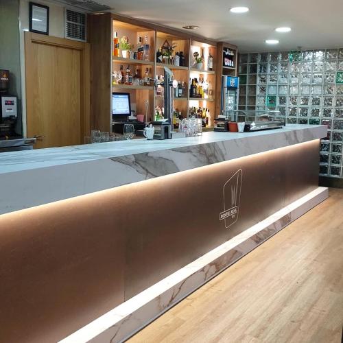 a bar in a restaurant with a counter at Hostal Real in Plasencia