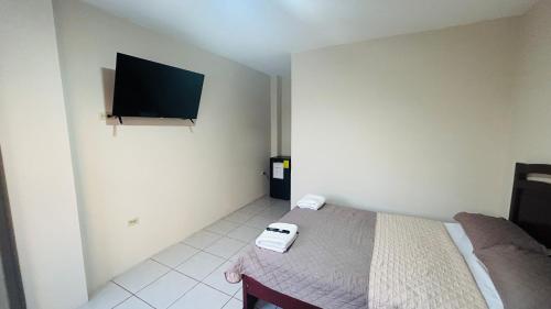 a bedroom with a bed and a flat screen tv at NCG Suite in Guayaquil