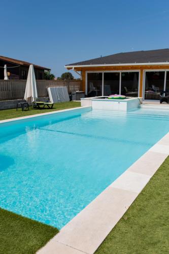 a large blue swimming pool in front of a house at Gothes Chalet Albertito in Ponte de Vagos