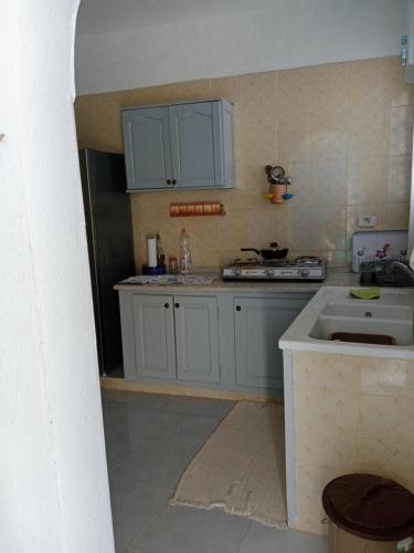 a kitchen with blue cabinets and a sink at Une belle maison djerbienne in Djerba