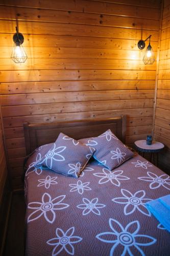 a bed in a wooden room with two pillows on it at Gothes Chalet Albertito in Ponte de Vagos