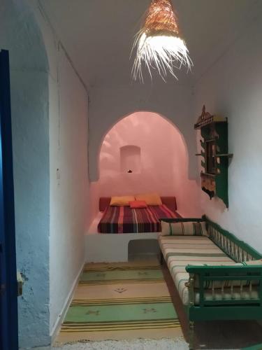 a room with a bed in the corner of a room at Une belle maison djerbienne in Djerba