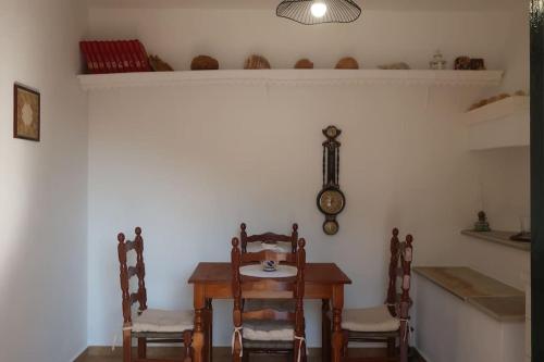 a dining room with a table and chairs and a clock at Trikeri pleasant stay in Ayía Kiriakí