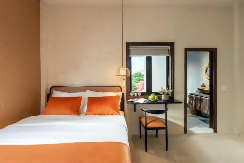 a bedroom with a bed and a table and a mirror at Coastal Village An Bàng Hội An in An Bang