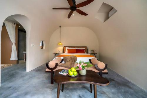 a bedroom with a bed and a table with fruit on it at Coastal Village An Bàng Hội An in An Bang