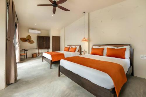 a bedroom with two beds and a ceiling fan at Coastal Village An Bàng Hội An in An Bang