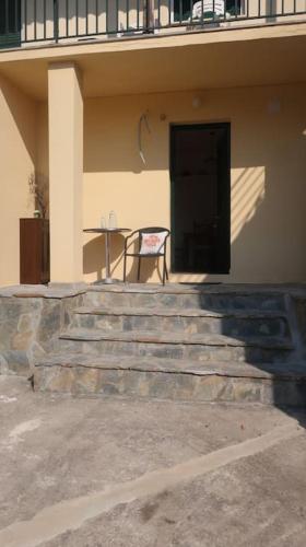 a chair sitting in front of a building with a table at Trikeri pleasant stay in Ayía Kiriakí