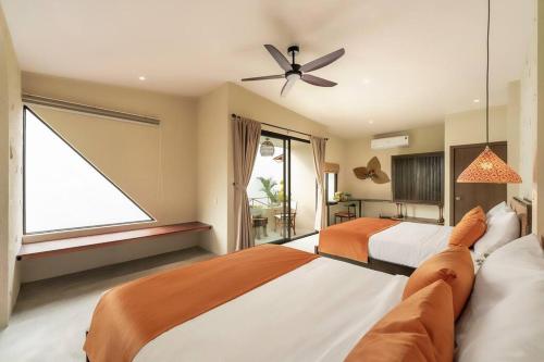 a large bedroom with two beds and a window at Coastal Village An Bàng Hội An in An Bang