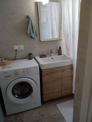 a bathroom with a washing machine and a sink at Trikeri pleasant stay in Ayía Kiriakí