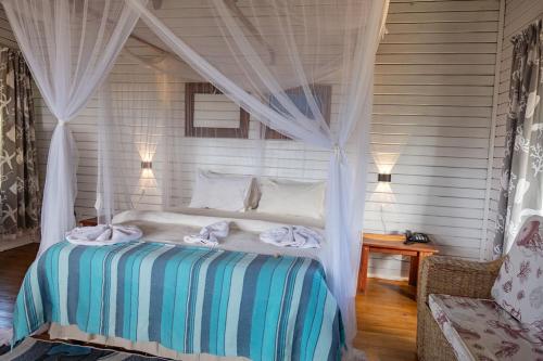 a bedroom with a bed with a canopy at East Africa Safaris in Chizavane