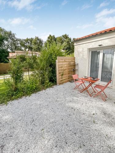 a picnic table and a chair in a gravel yard at Duplex au vert près de Royan - Appartement 4 in Médis
