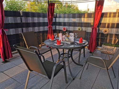a table and chairs on a patio with red drapes at Minsu Hotel in Mülheim an der Ruhr
