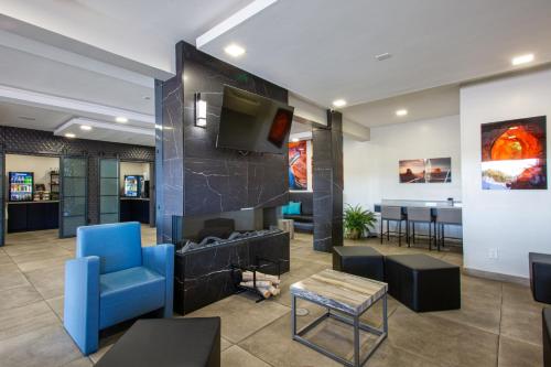 a lobby with a fireplace and a blue chair at Hotel Elev8 Flagstaff, Trademark Collection by Wyndham in Flagstaff