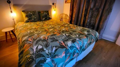 a bedroom with a bed with a colorful comforter at Appartement du Fort Griffon in Besançon