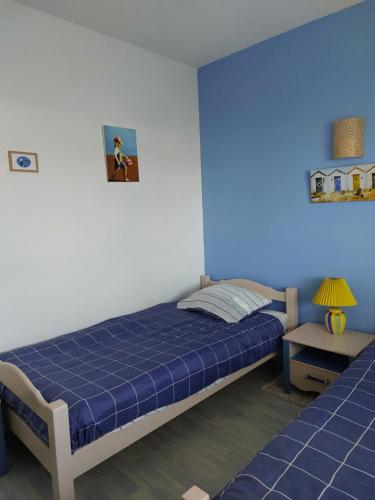- une chambre bleue avec un lit et une table dans l'établissement Style Vintage chic à 20 M de la plage, à Saint-Georges-de-Didonne