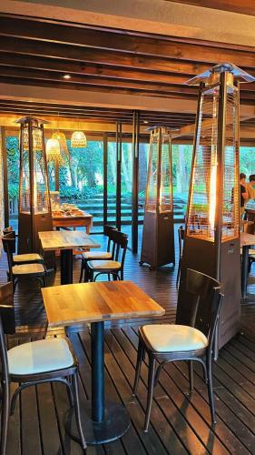 a restaurant with wooden tables and chairs and windows at Sonidos Del Bosque in Mar de las Pampas