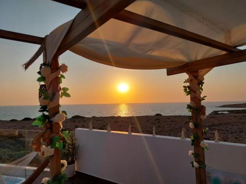 a gazebo with the sunset in the background at Tramonto Luxury Villa No1- Breathtaking sunset view in Karpathos Town