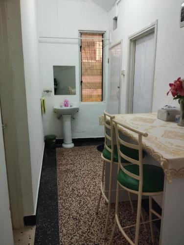 a bathroom with a sink and a table and chairs at Mombasa Comfort House, Old Town in Mombasa