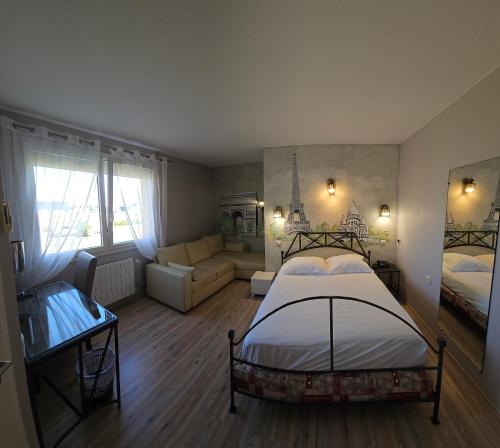 a bedroom with a bed and a living room at Hotel Restaurant Champ Alsace in Haguenau