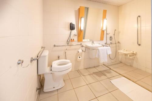 a bathroom with a toilet and a sink at HUS HOTEL Dourados in Dourados