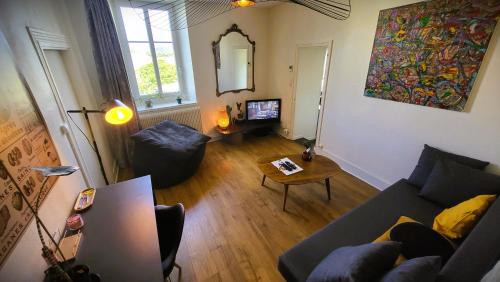 a living room with a couch and a table at Appartement du Fort Griffon in Besançon