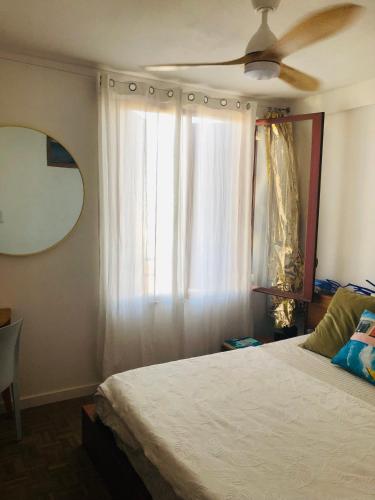 une chambre avec un lit et un ventilateur de plafond dans l'établissement Marseille Joliette Panier, vue mer et Terrasse T1, à Marseille