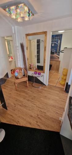 a living room with a mirror and a chair at Am alten Siel in Wilhelmshaven