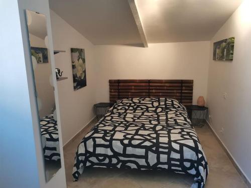 une chambre avec un lit avec une couette noire et blanche dans l'établissement Chambre d'Hôtes dans Villa - La Londe Les Maures - Résidence d'Artiste 