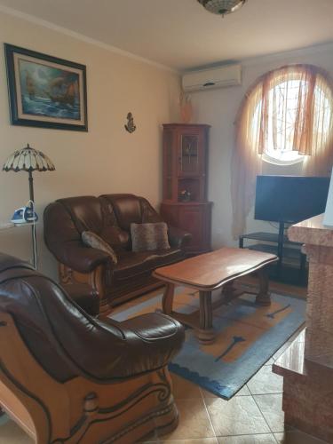a living room with a leather couch and a table at Aurora Spa in Kunje