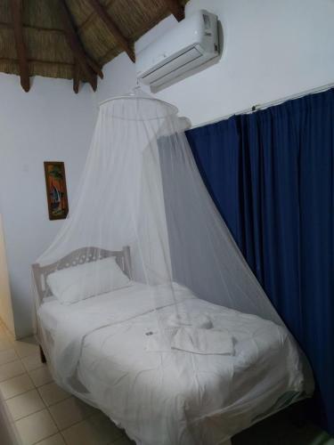 a bedroom with a bed with a mosquito net at East Africa Safaris in Chizavane